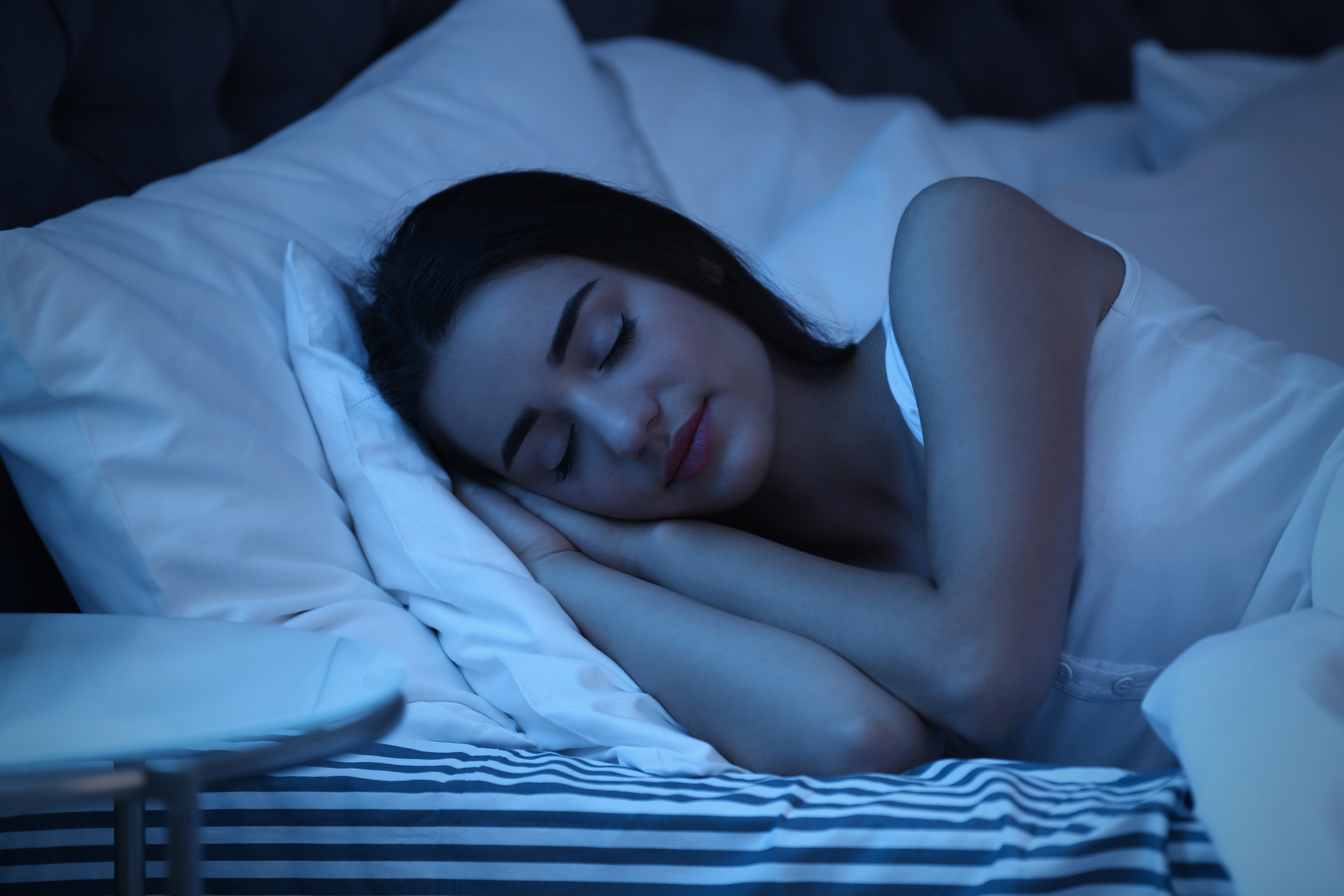 Young Woman Sleeping in Bed at Night. Sleeping Time